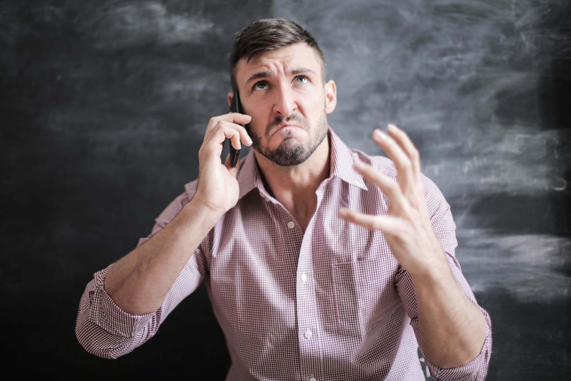 A traveler looking stressed while examining their smartphone screen, possibly after their eSIM disappeared.