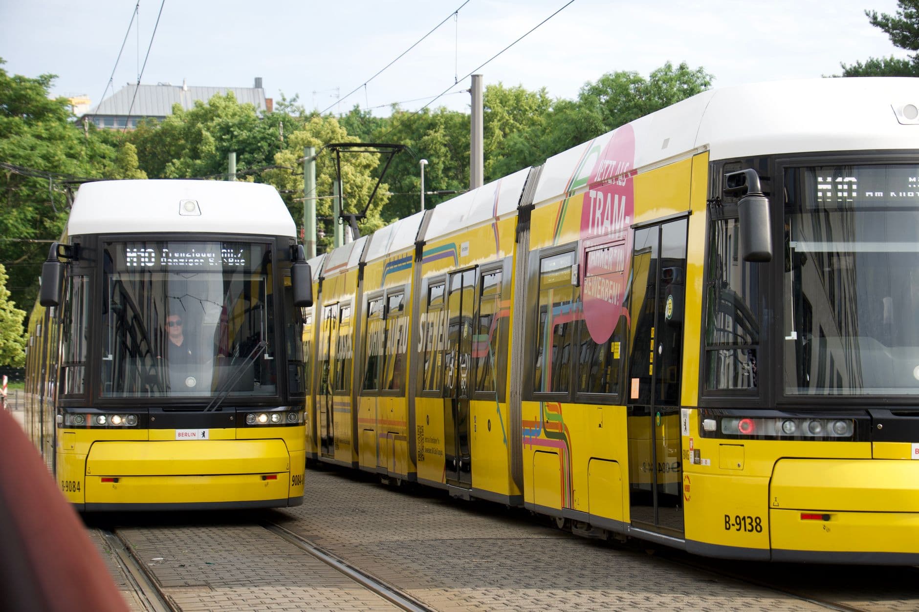 A busy Berlin street with a yellow tram and people walking, illustrating staying connected with a Germany eSIM