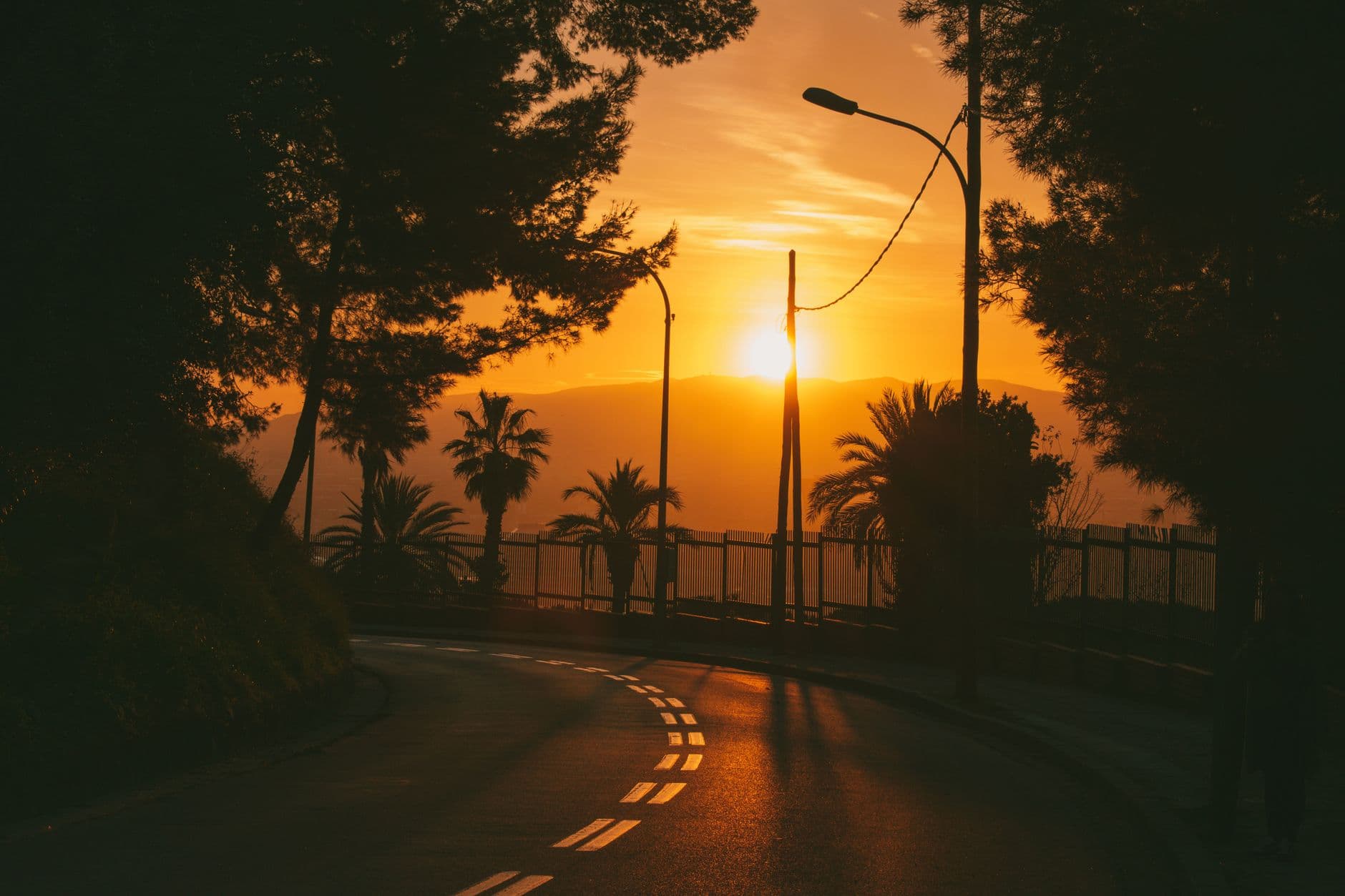 A busy Barcelona street at golden hour with a traveler checking their phone