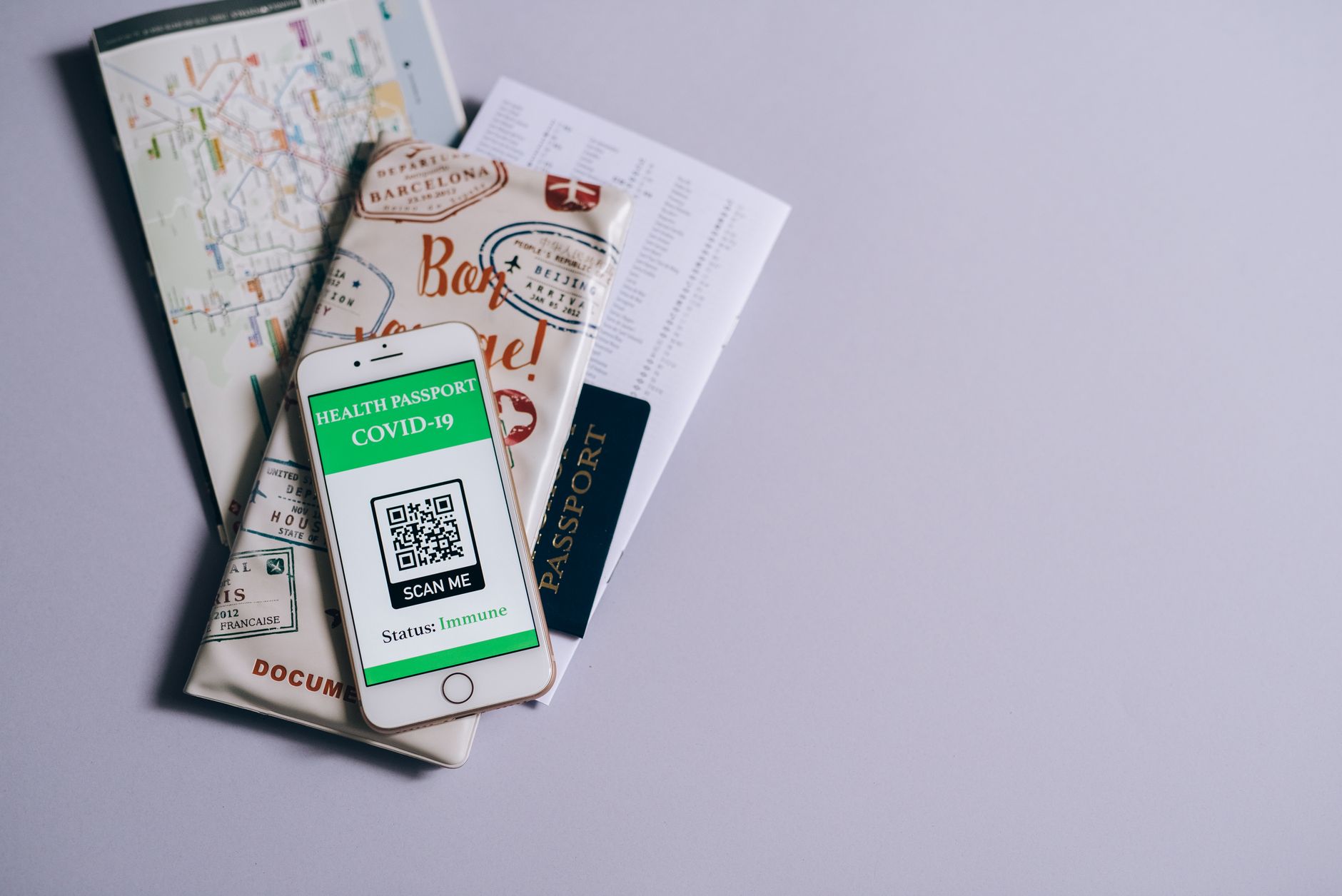 A traveler holding a smartphone, scanning a QR code on a screen to activate an eSIM, with a blurred airport background.