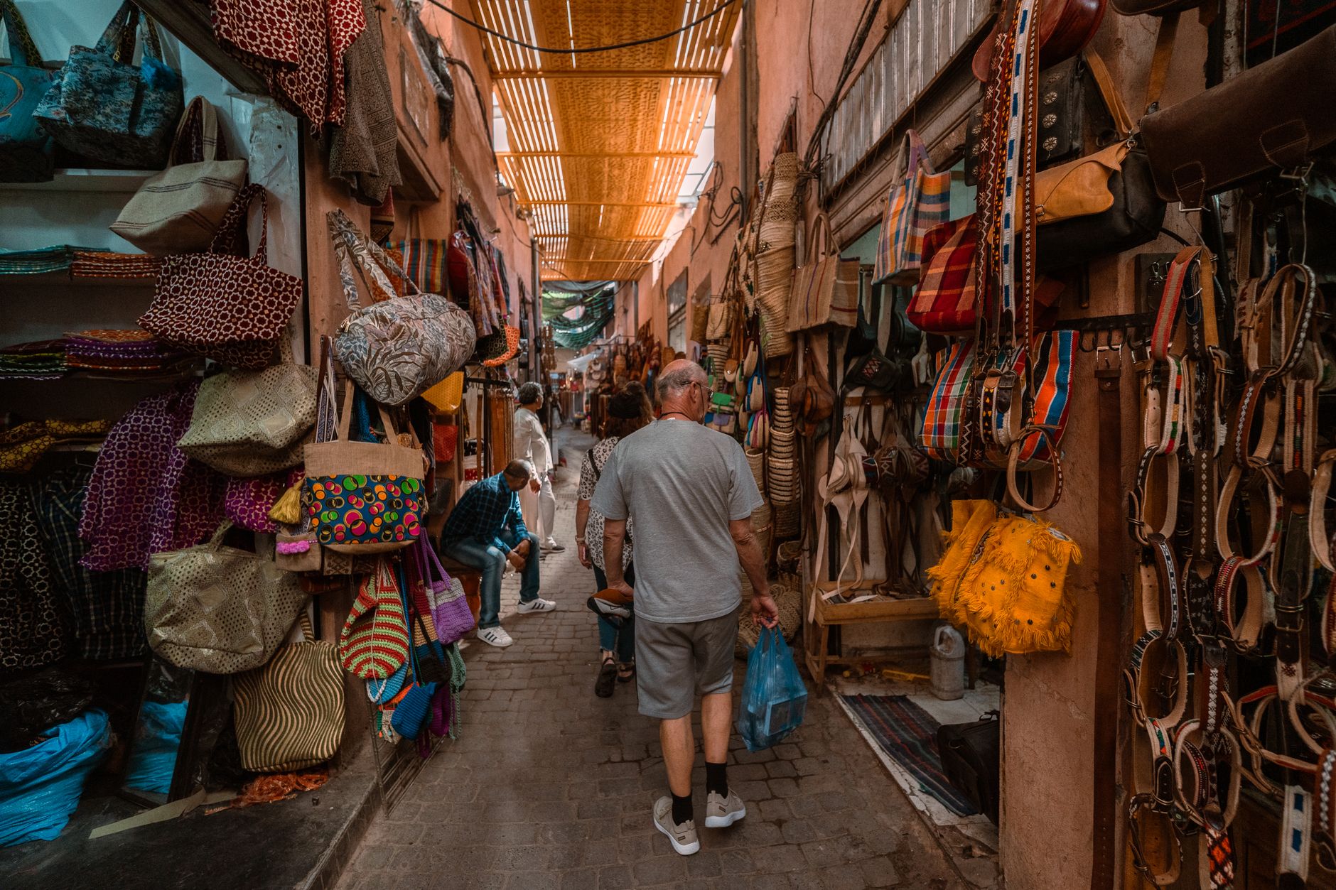 A stall in a Marrakech souk displaying hundreds of colorful leather babouches, traditional Moroccan slippers, arranged neatly for sale.