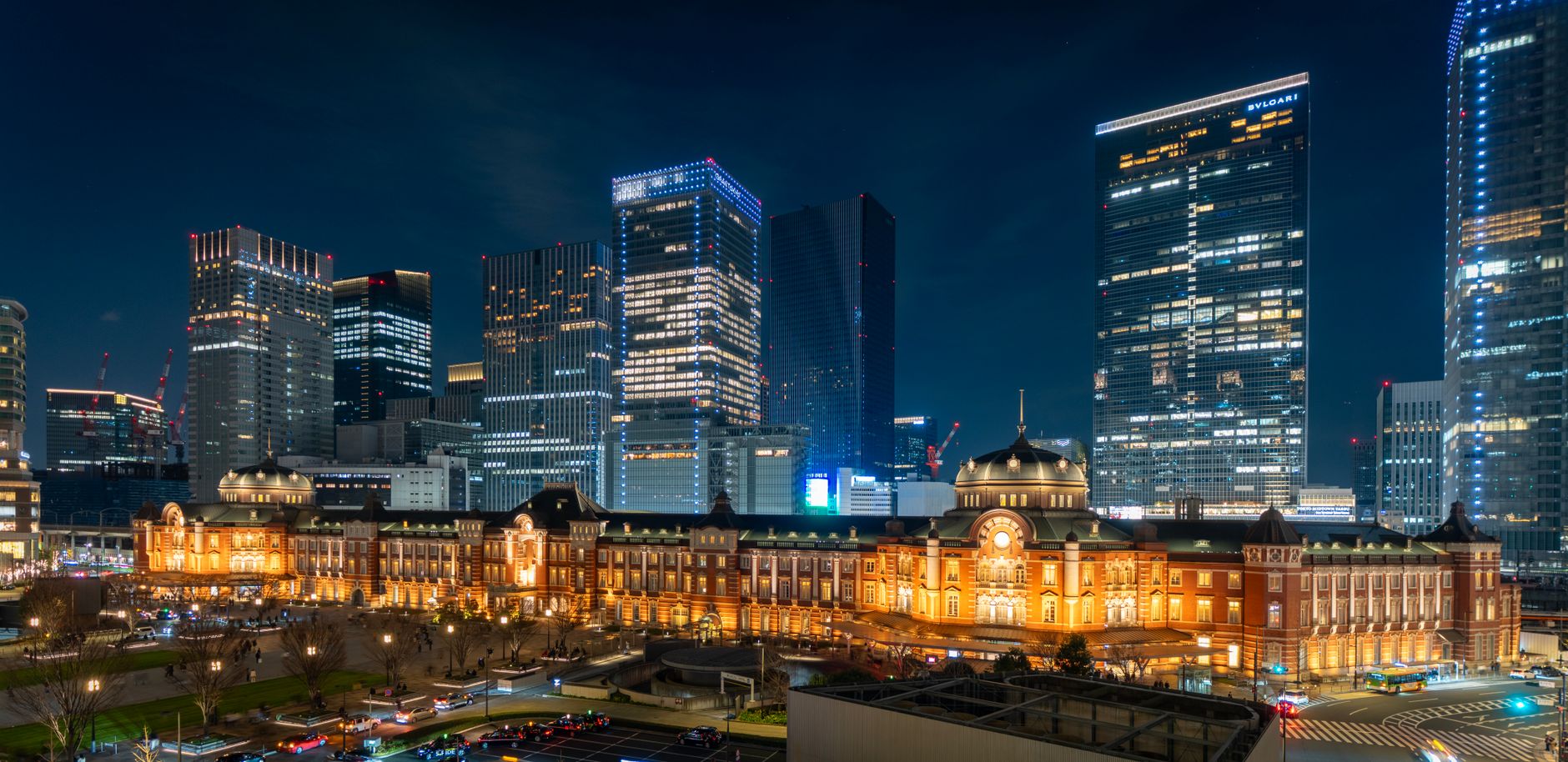 A bustling Tokyo cityscape at night, with a train passing by, illustrating the city's vibrant energy.