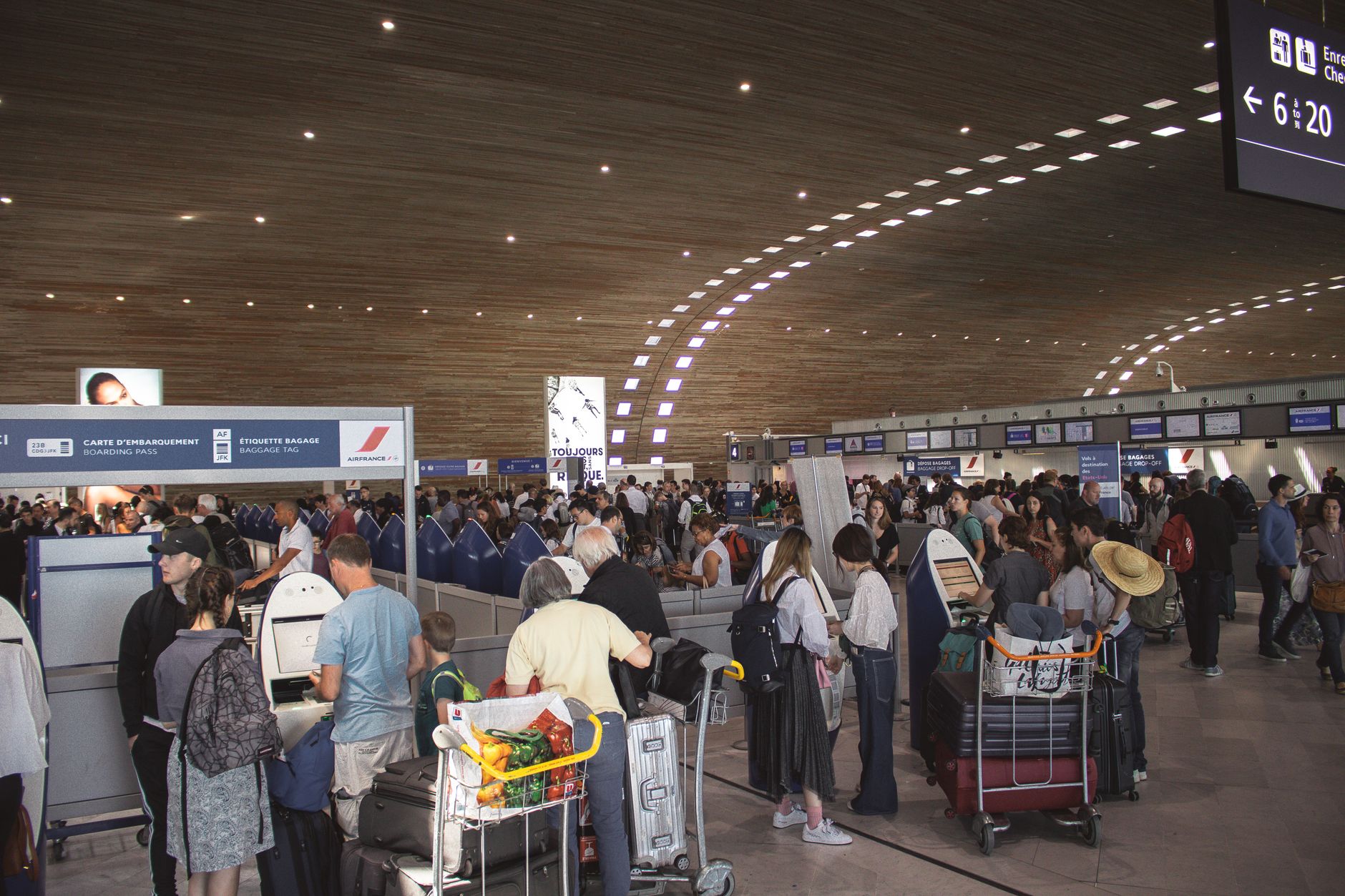 Reisende stehen in einer langen Schlange vor einem SIM-Karten-Verkaufsstand am Flughafen.