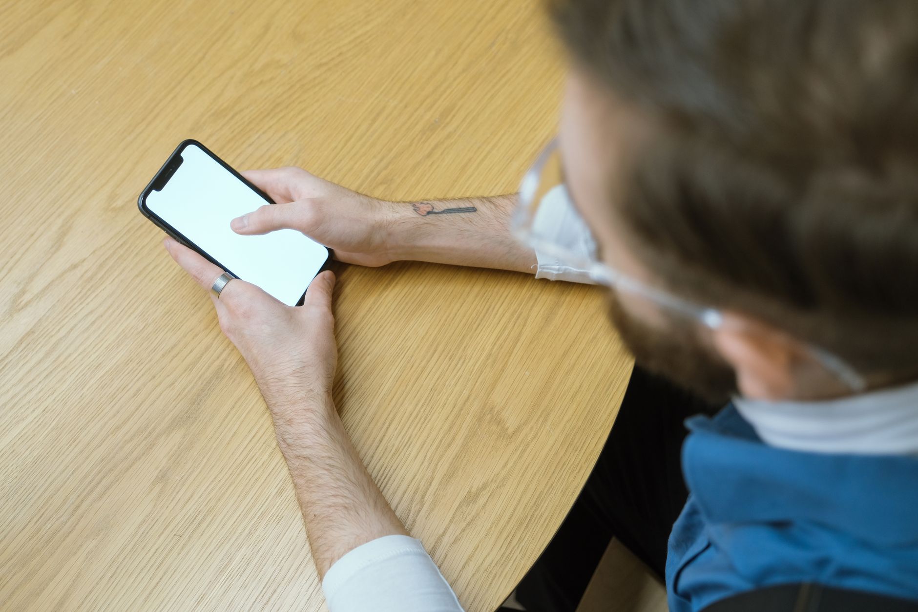A person's hands holding a smartphone, navigating through the phone's settings menu, with various options visible.