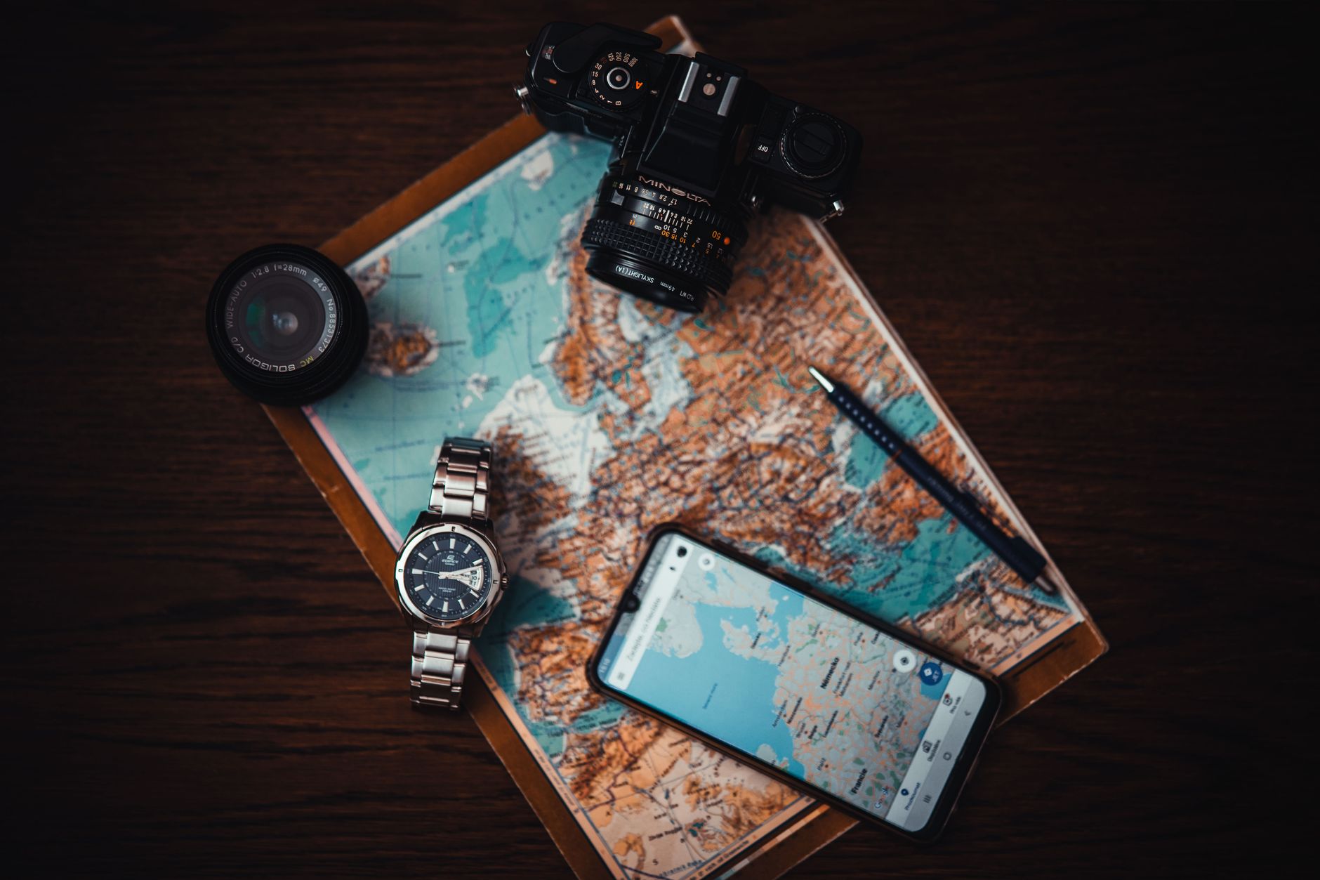 A world map beside a smartphone, illustrating a comparison of the best travel eSIM apps in 2026.