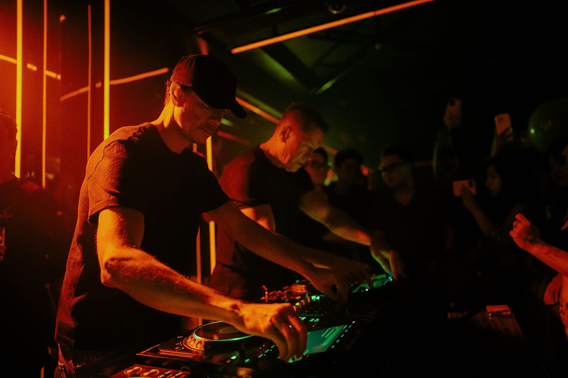 A crowded techno club interior with laser lights and people dancing.