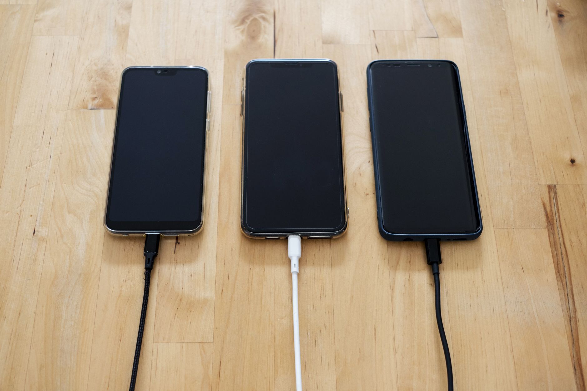 Handy am Ladekabel auf Reisen mit Stadtkulisse im Hintergrund