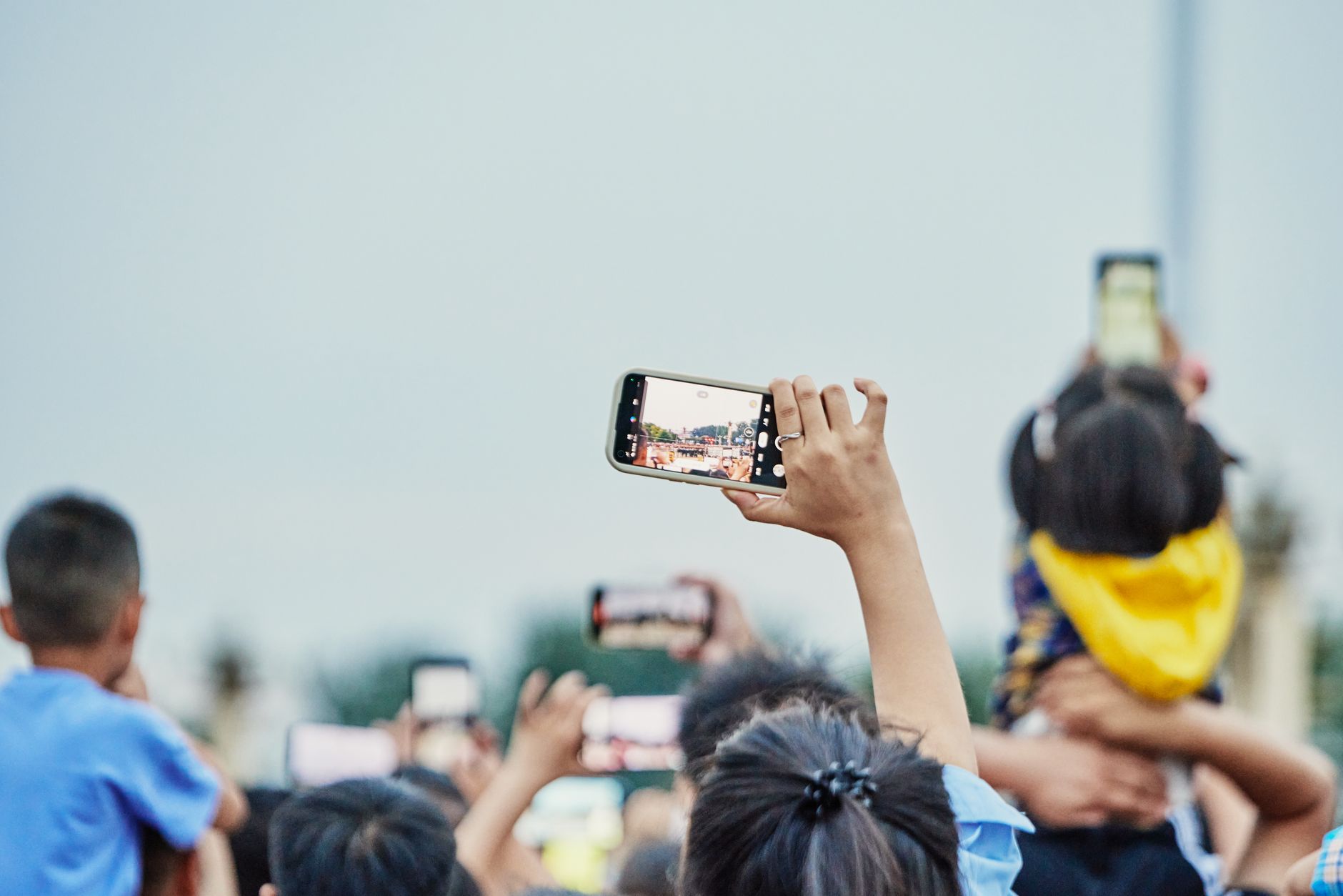 A collection of different smartphone models held in various hands, showcasing diverse designs.