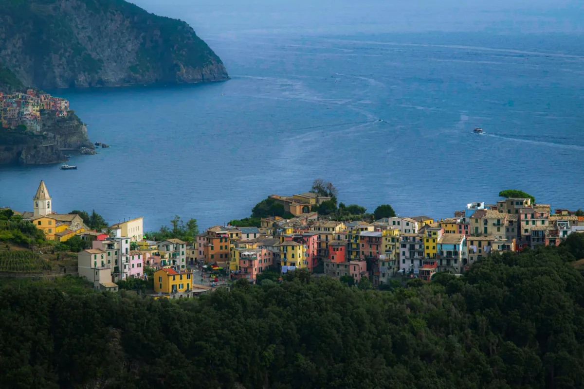 Overhead view of Amalfi Coast Italy showing colorful hillside buildings, boats in turquoise water, and dramatic cliffs