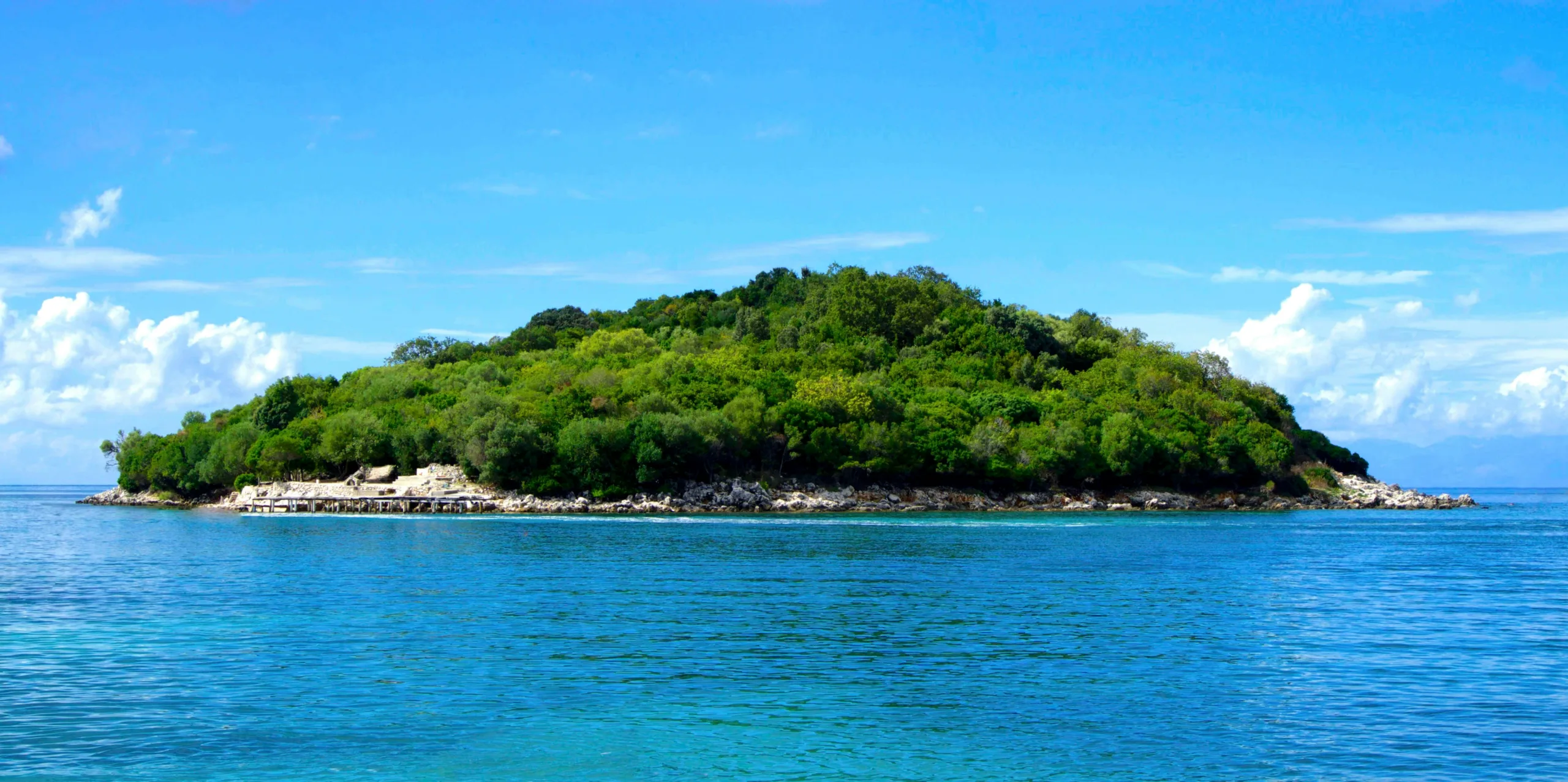 Ksamil Beach Albania with white sand, turquoise sea, and small islands in the background